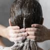 Frau wäscht Haare unter der Dusche