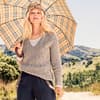 Model in beigefarbenem Sommerpullover mit V-Ausschnitt