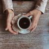 Tasse Kaffee zwischen den Händen