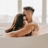 Mann und Frau sitzen umschlungen in der Badewanne