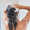 Frau shampooniert Haare ein