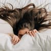 Frau mit langen Haaren im Bett