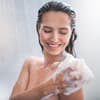 Frau seift Körper ein unter der Dusche