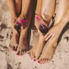 Frauen mit lackierten Finger- und Fußnägeln am Strand