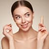 Frau trägt Concealer auf 