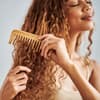 Frau kämmt lockige Haare