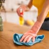 Frau entfernt Staub mit Hausmitteln