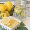 Zitronen und ein Glas mit Wasser und Zitronenscheiben