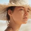 Frau mit Sonnencreme unter Make-up