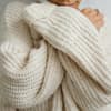 Eine Frau trägt einen selbst gestrickten Pullover aus warmer Wolle