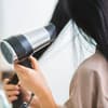 Frau föhnt sich die Haare