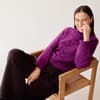 Model in fuchsiafarbenem Zopfmuster-Rollkragenpullover von Lana Grossa