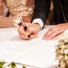 Brautpaar unterschreibt bei standesamtlicher Hochzeit 