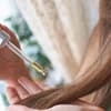 Beauty-Chefin Isabell Stiller trägt Apfelessig mithilfe einer Pipette auf dem Haar auf