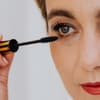 Frau trägt wasserfeste Mascara auf ihre Wimpern auf