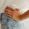 Frau trägt eine zu eng gewordene Jeans