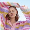Model in bunt gestreiftem Natural Superkid Tweed Pullover von Lana Grossa