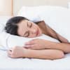 Eine Frau schläft in ihrem Bett