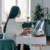 Eine Frau sitzt am Laptop und arbeitet