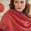 Eine Frau im selbstgestrickten Poncho mit Wolle von Lana Grossa