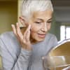 Reife Frau benutzt Anti-Aging-Produkte