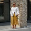 Eine Besucherin der Kopenhagen Fashion Week kombiniert silberne Sandalen zum Faltenrock