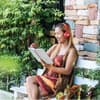 Eine Frau liest ein Buch im Garten