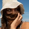 Frau trägt einen Sonnenhut am Strand