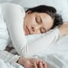 Eine Frau schläft in ihrem Bett