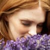 Frau riecht an heilenden Blumen - So lindern Ringelblume, Lavendel und Arnika Ihre Beschwerden