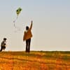 Mutter und Kind lassen auf Herbstwiese einen Drachen fliegen
