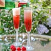 Sekt wird auf Erdbeeren eingeschenkt