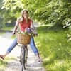 Eine junge Frau fährt bei schönem Wetter Fahrrad und ist glücklich