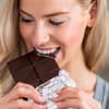 Frau isst Schokolade - ist Zucker ungesund für die Haut?