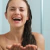 Lachende Frau in der Dusche - Tipps für eine bessere Durchblutung 
