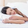 Ein Frau liegt im Bett und schläft - Tipps für das Schlafen, trotz Hitze gibt es hier.