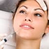 Frau bekommt auf einem Arztstuhl Botox gespritzt