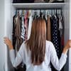 Junge Frau räumt ihren Kleiderschrank auf