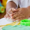 Kinderhände beim Selbermachen von Knete