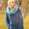 Blonde Frau trägt Mohair Zopfpulli mit Loopschal / mit FÜR SIE Shop-Logo