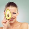 Diese Lebensmittel gelten als Fatburner: Frau hält Avocadohälfte