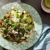 perlgraupensalat mit Granatapfel und Feta auf einem Teller, angerichtet mit Avocado
