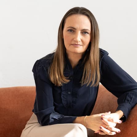 Rechtsexpertin Dr. Carolin Eyand sitzt auf einem Sofa und wirkt souverän.