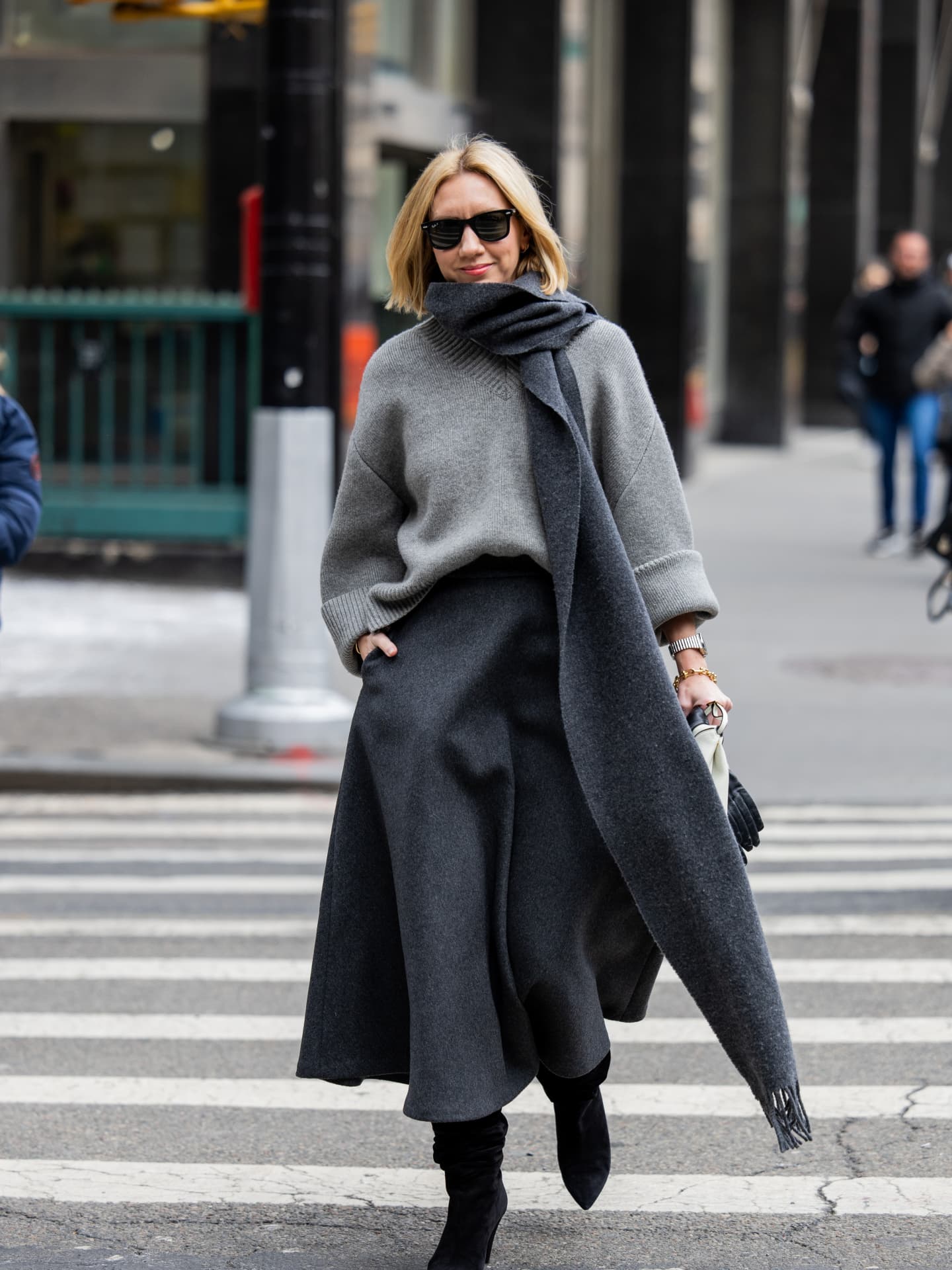 Stricktrends 2025 - Lisa Aiken trägt einen grauen V-Pullover