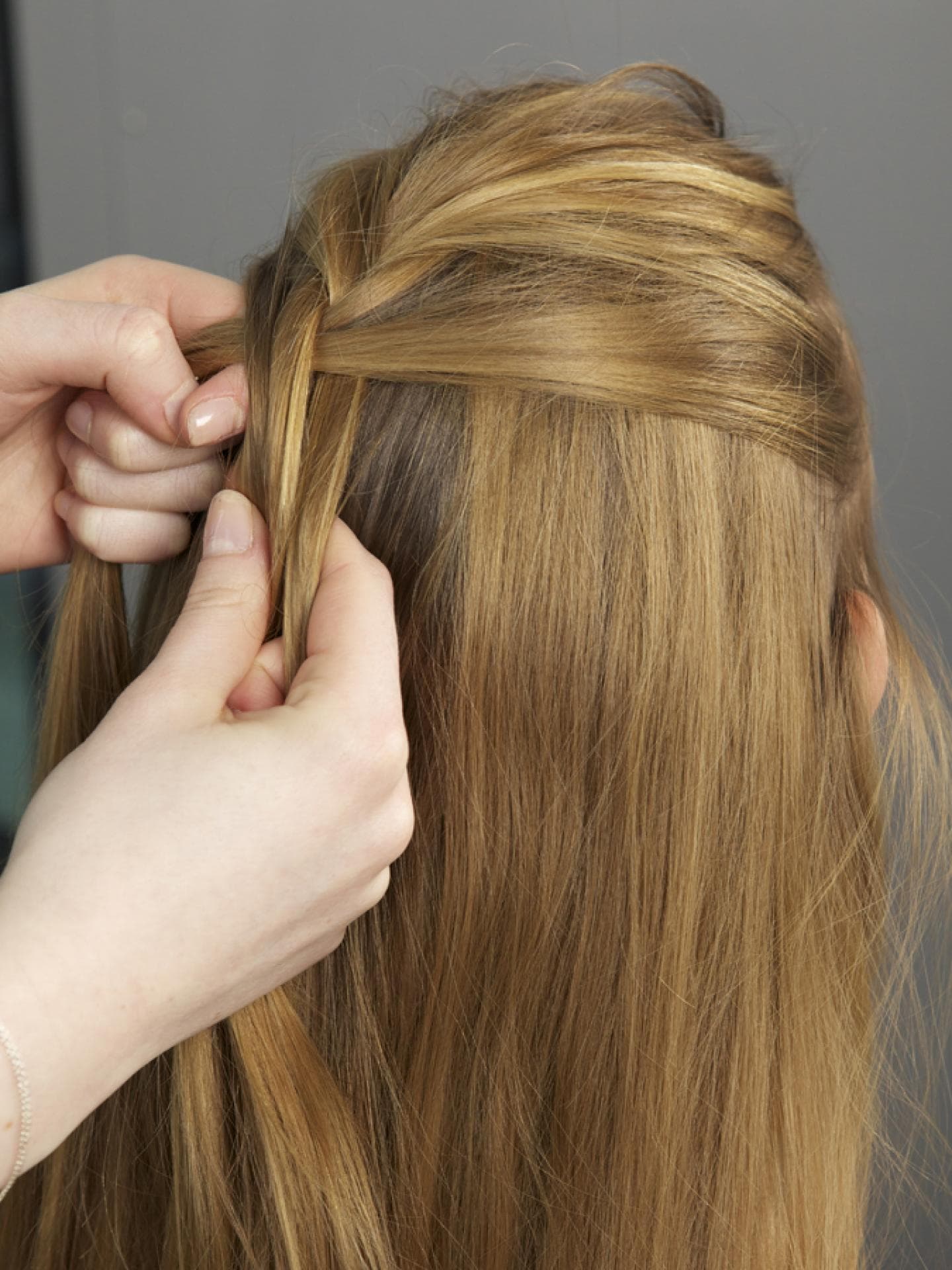 Haare einer Frau werden am Hinterkopf geflochten Haare einer Frau werden am Hinterkopf geflochten