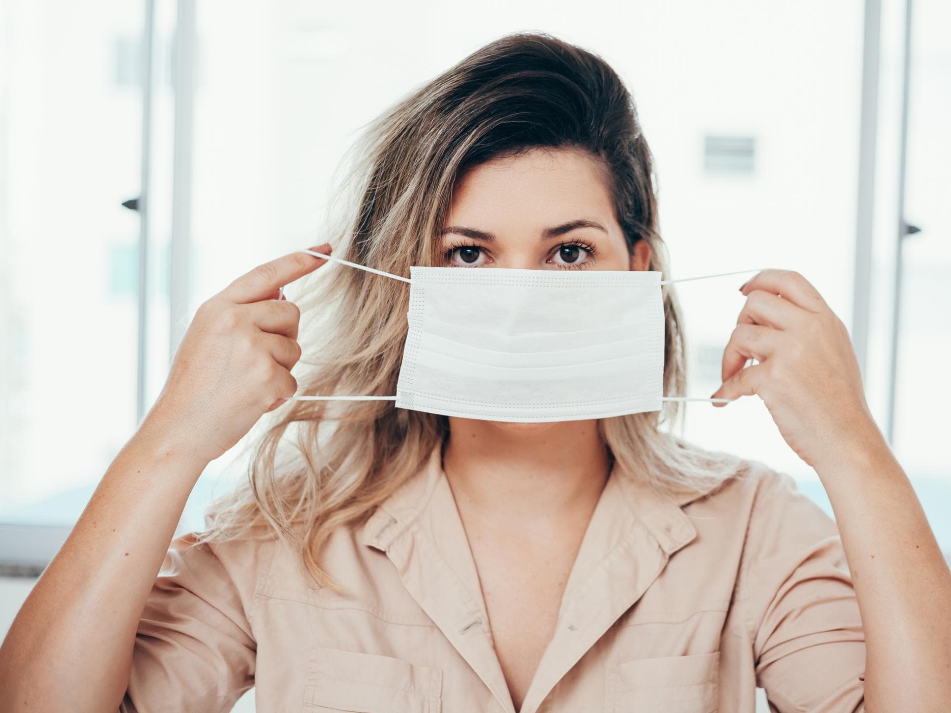 Frau setzt Maske auf
