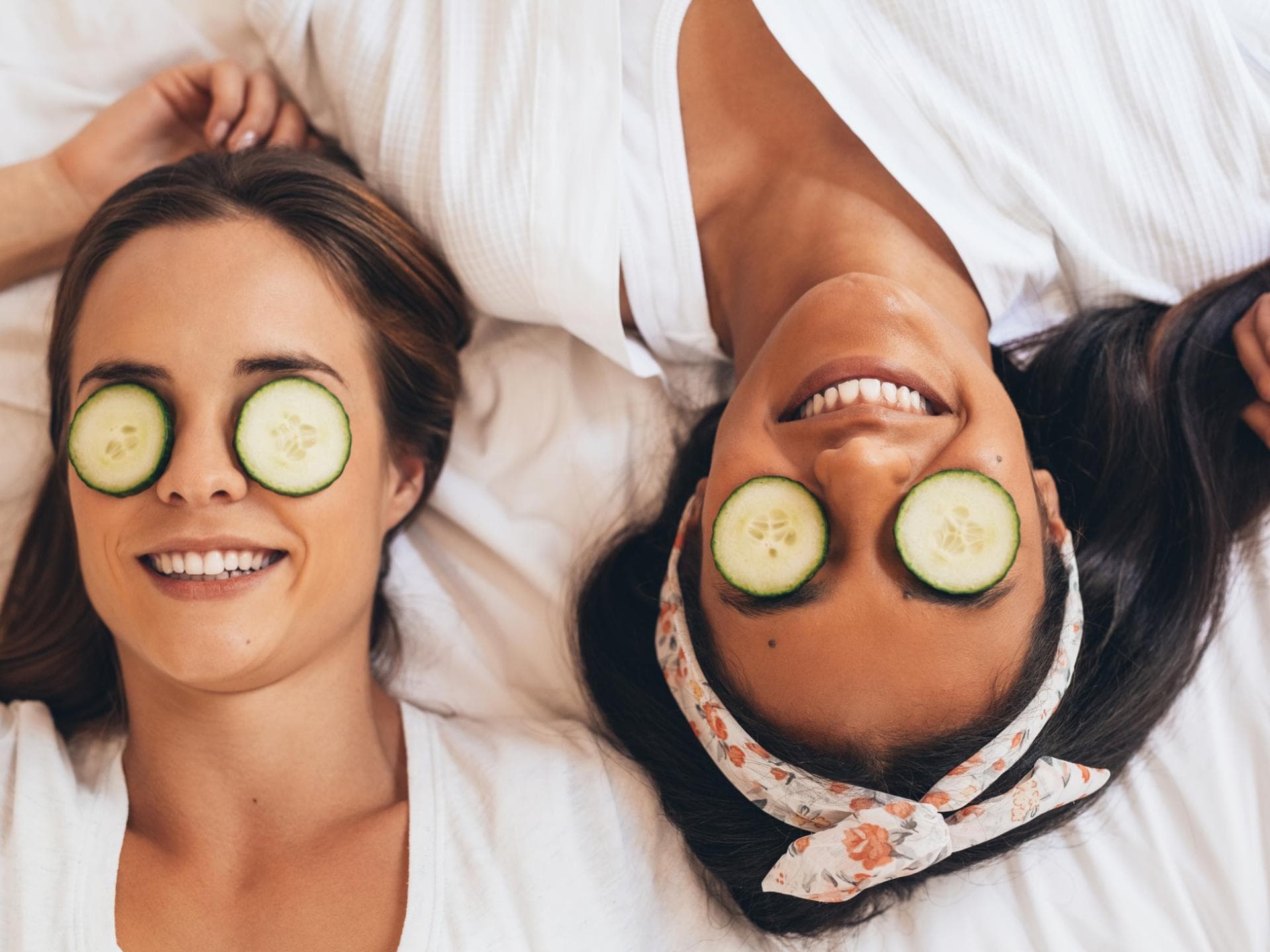 Zwei Frauen mit Gurkenscheiben auf den Augen