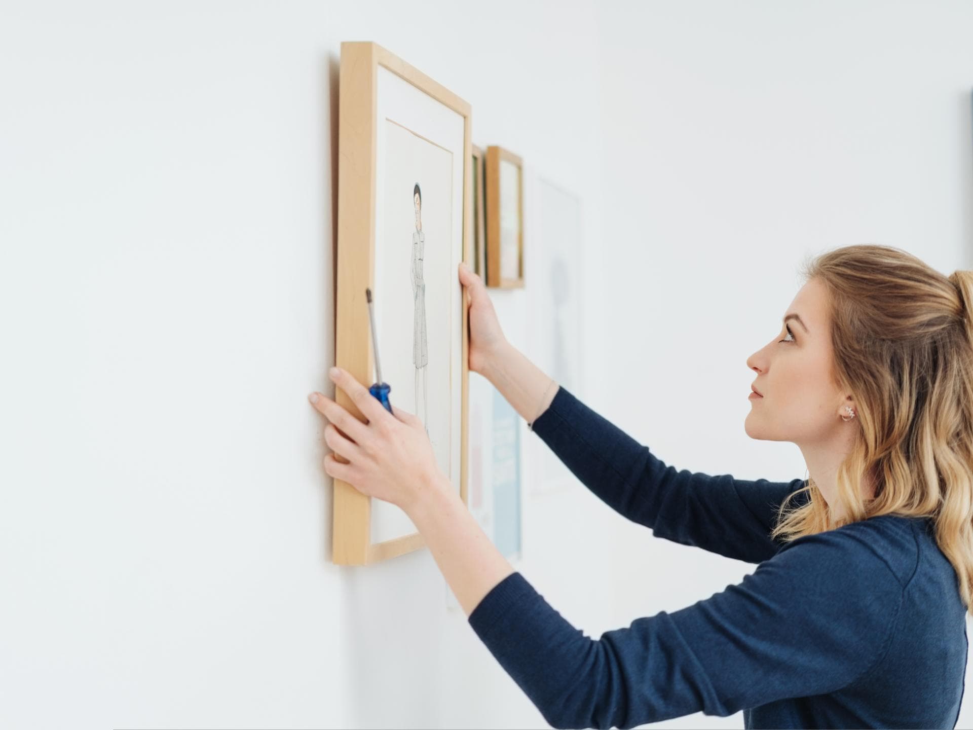Frau hängt Bild auf