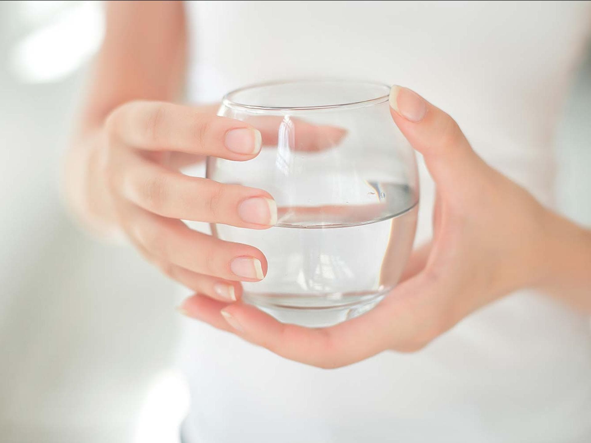 Viel trinken ist gesund: Frau hält ein Glas mit Wasser