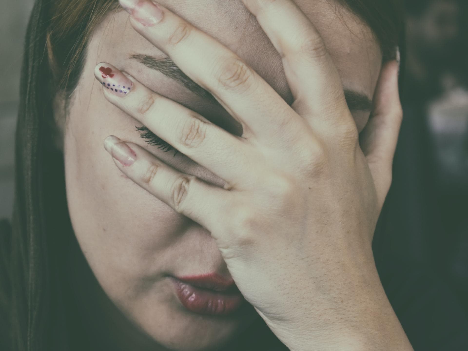 Frau schlägt Hand vors Gesicht